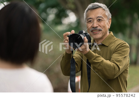 女性の写真を撮るシニア男性 95578242