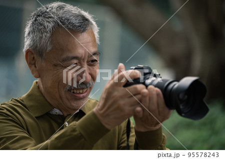 写真を撮るシニア男性 95578243