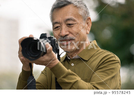 写真を撮るシニア男性 95578245