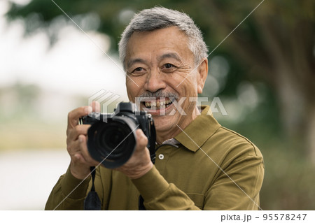 写真を撮るシニア男性 95578247