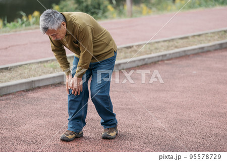 川沿いを歩くシニア男性の足元 95578729