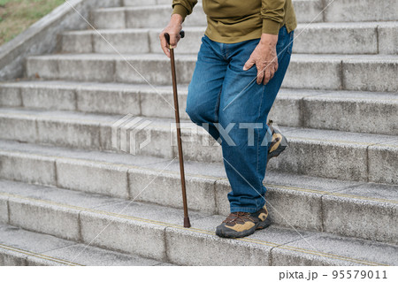 杖をついて階段を下るシニア 95579011
