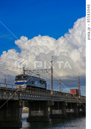 夏の入道雲を背景に走る貨物列車EF210-123桃太郎 95583046