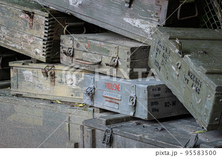 A stack of old wooden military green boxes with ammunition. 95583500