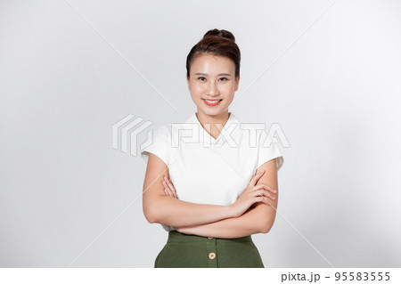 Smiling young beautiful Asian businesswoman doing arm crossed gestures in isolated studio white background Smiling young beautiful Asian businesswoman doing arm crossed gestures in isolated studio white background 95583555