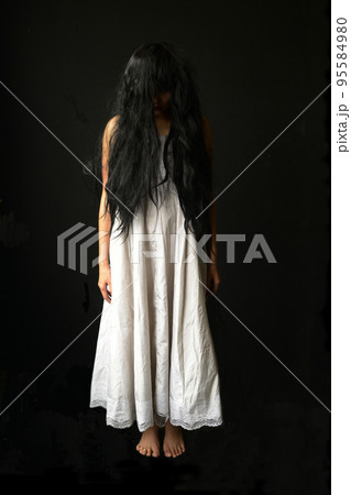 Happy Halloween day in Scary ghost woman. Asian ghost or zombie horror creepy scary have hair covering face and eye reach arm out at abandoned house dark room.  95584980