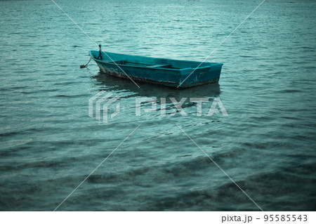 Old alone boat floating in the calm water 95585543