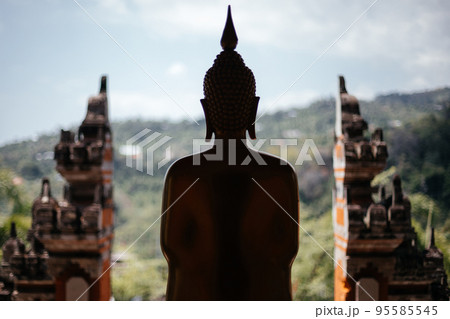 Silhouette of a buddha statue on the background of the balinese gate. 95585545