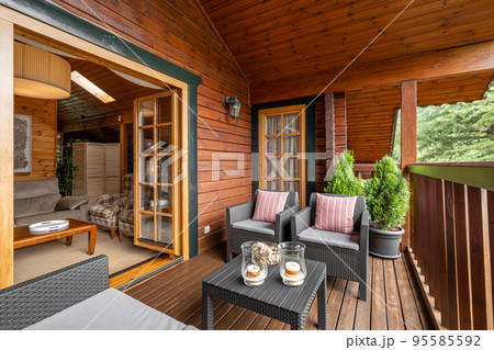 Beautiful wooden country home in the village. Cozy terrace with chairs and table in vacational house for rent. Beautiful wooden country home in the village. Cozy terrace with chairs and table in vacational house for rent. 95585592
