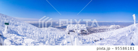 [パノラマ写真] 快晴の樹氷原を見渡す (山形県、地蔵山頂駅)  95586181