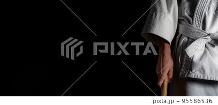 A person practicing aikido on a black background. 95586536
