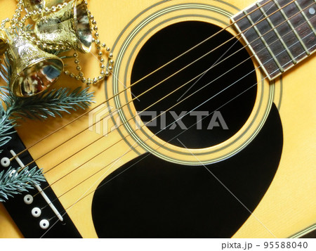 フォークギターとクリスマス用のベルの飾り物 フォークギターとクリスマス用のベルの飾り物 95588040