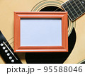 フォークギターと白紙が入った横長の木製のフレーム 95588046