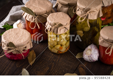 Pickled vegetables in glass jars. 95588428