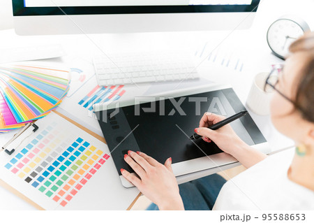 ペンタブで仕事するグラフィックデザイナー・イラストレーターの女性 95588653
