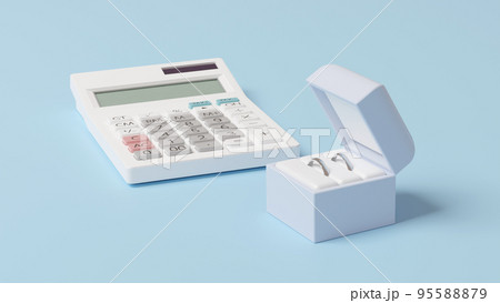 平面上に置かれた2つの結婚指輪を収めたケースと白い電卓の3Dレンダリングイラスト 95588879