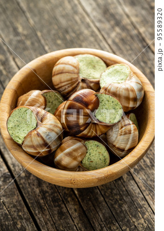 Snails with parsley butter, Bourgogne Escargot Snails in bowl. Delikatese food. Snails with parsley butter, Bourgogne Escargot Snails in bowl. Delikatese food. 95589320