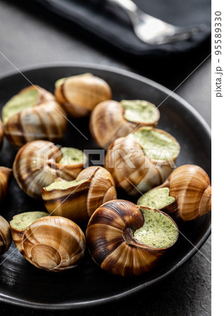 Snails with parsley butter, Bourgogne Escargot Snails on plate. Delikatese food. Snails with parsley butter, Bourgogne Escargot Snails on plate. Delikatese food. 95589330