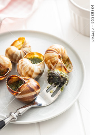 Snails with parsley butter, Bourgogne Escargot Snails on plate. Delikatese food. 95589334