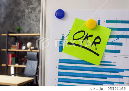 Whiteboard with financial report and OKR Objectives and Key Results sticker. 95591166