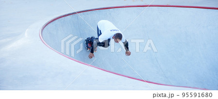 One man, male roller skater on rollerblades training at modern skate park, outdoors. Action, motion, skills and challenges. Doing different tricks 95591680