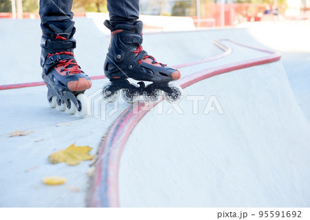 Man's legs in rollerblades. Leisure activities outdoors in autumn sunny day. Concept of active lifestyle, sport, hobbies. 95591692