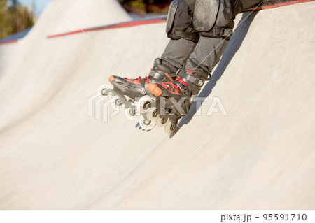 Man's legs in rollerblades. Leisure activities outdoors in autumn sunny day. Concept of active lifestyle, sport, hobbies. Man's legs in rollerblades. Leisure activities outdoors in autumn sunny day. Concept of active lifestyle, sport, hobbies. 95591710