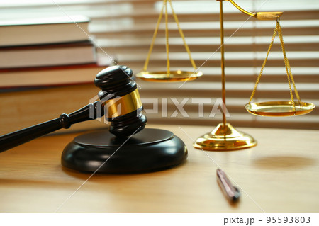 Lawyer or judge's hammer in the court. Auction's hammer and judgement golden scale are on wood table. Law subject. Judgement subject to judge people. 95593803