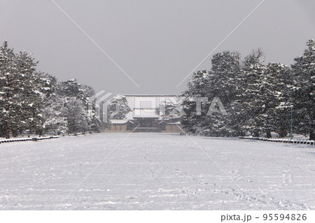雪降る京都御所建礼門に陽が射す風景 95594826