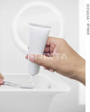 The guy squeezes toothpaste on the toothbrush 95595233