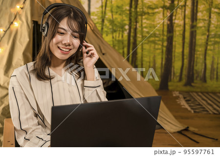 ワーケーション　キャンプ場で仕事をする若い女性 95597761