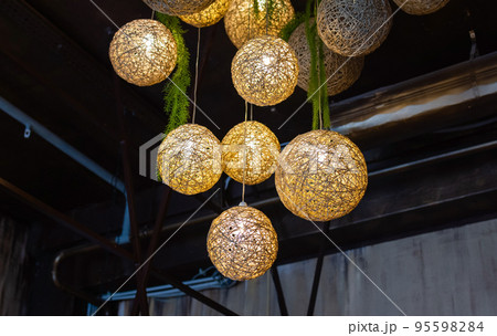 white lightning balls. modern art luxury chandelier made with balls with lamp inside every one, which conncet to beautiful flower with silver legs. Lighting ball hanging from the ceiling on background white lightning balls. modern art luxury chandelier made with balls with lamp inside every one, which conncet to beautiful flower with silver legs. Lighting ball hanging from the ceiling on background 95598284