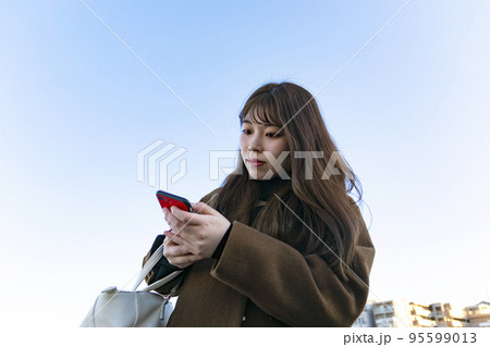 赤いスマホを見る女性 赤いスマホを見る女性 95599013