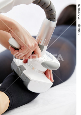 woman in a black suit for LPG massage drinking water before LPG massage. Anti-cellulite body care concept. LPG massage machine on background. woman in a black suit for LPG massage drinking water before LPG massage. Anti-cellulite body care concept. LPG massage machine on background. 95599070