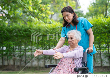 Doctor help Asian senior or elderly old lady woman patient exercise on wheelchair with happy in park. Doctor help Asian senior or elderly old lady woman patient exercise on wheelchair with happy in park. 95599791