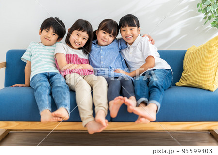 ソファーに仲良く座る小学生 95599803