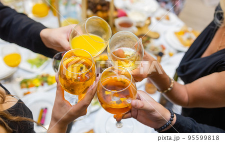 Clinking glasses with alcohol and toasting, party. 95599818