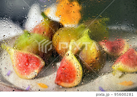 Figs fruits placed on a small plate behind rainy window 95600281