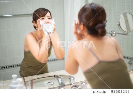 鏡の前で洗顔をしている女性のポートレート 95601215