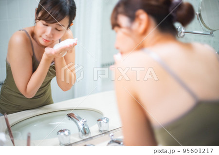 鏡の前で洗顔をしている女性のポートレート 95601217