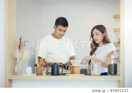 Couple to make, brew or drink coffee in kitchen home. Couple to make, brew or drink coffee in kitchen home. 95601335