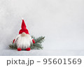 Christmas gnome in red hat with fir branch holiday card on light winter background 95601569