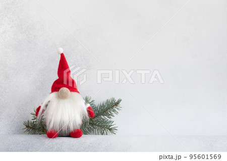 Christmas gnome in red hat with fir branch holiday card on light winter background 95601569