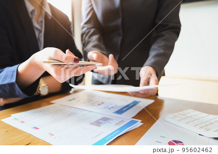 An auditor holds a pen pointing to documents to examine budgets and financial fraud An auditor holds a pen pointing to documents to examine budgets and financial fraud 95602462