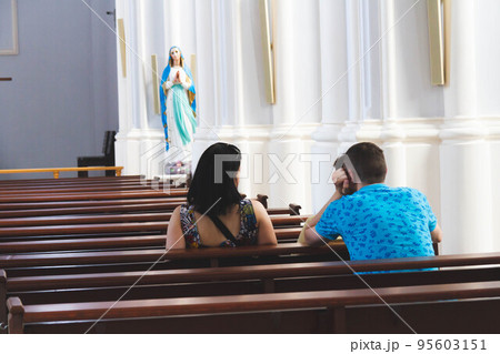 People pray in the church. Church parish. Believers sit on benches in the hall. 95603151