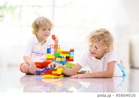 Child playing with toy blocks. Kids play. 95604010