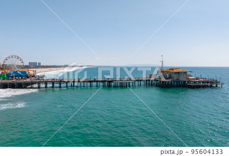 Famous Santa Monica ferris wheel amusement park in sunset light. Panoramic view of the Santa Monica Beach and the Pier Famous Santa Monica ferris wheel amusement park in sunset light. Panoramic view of the Santa Monica Beach and the Pier 95604133
