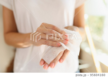 Woman cleaning hands using antibacterial wet wipes 95604160