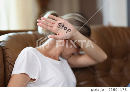 Woman showing palm with stop lettering, protesting against domestic violence Woman showing palm with stop lettering, protesting against domestic violence 95604178