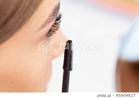 Beautiful smile young woman doing make up in her bathroom. Beautiful smile young woman doing make up in her bathroom. 95604627